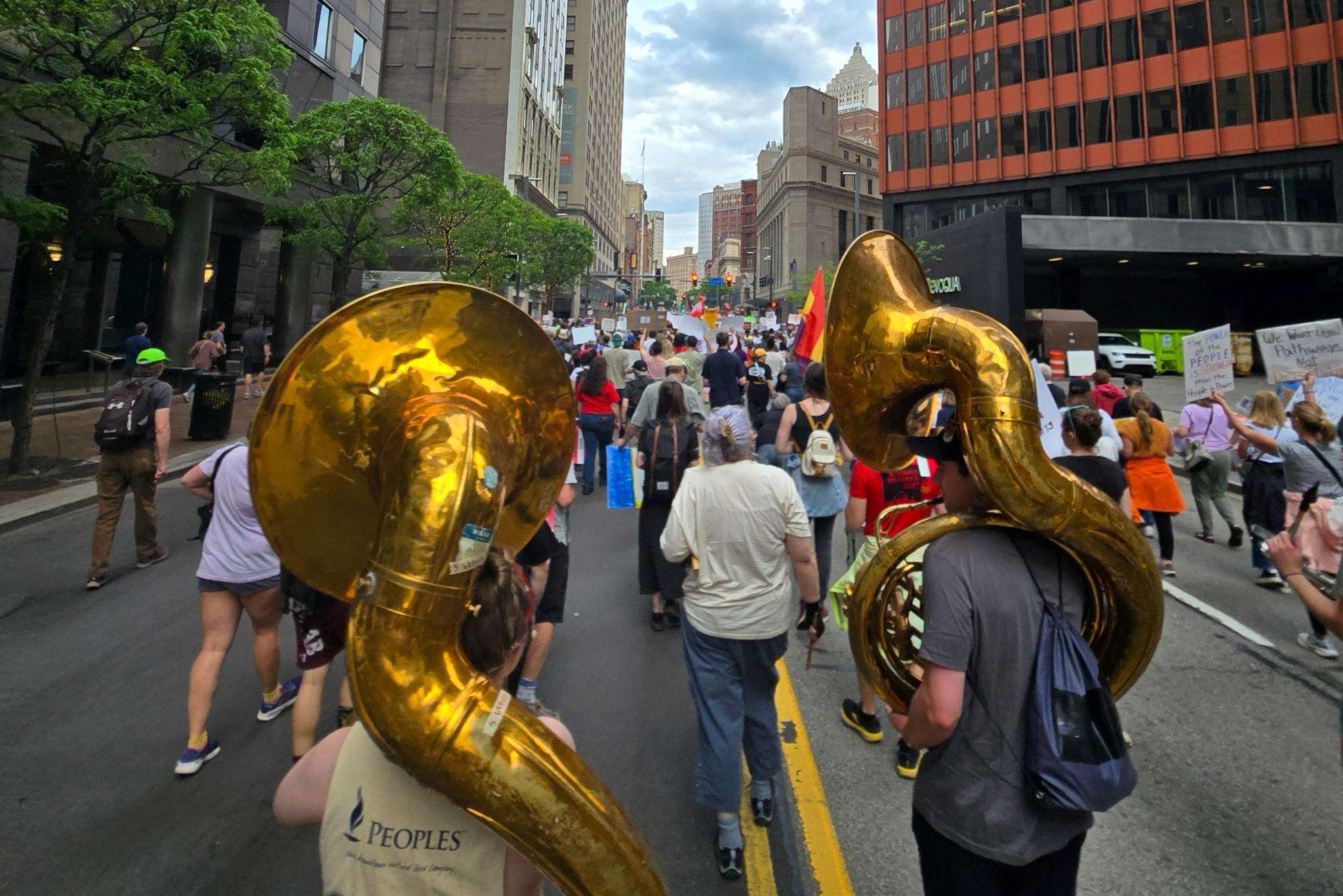 View from rear of band marching in the middle
                        of a city street